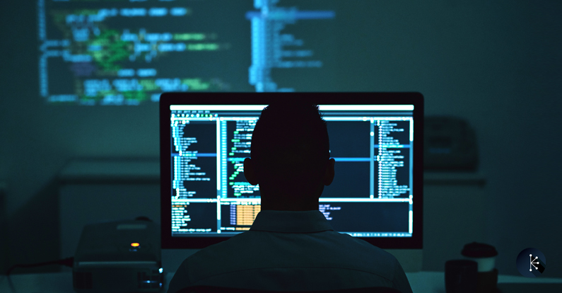 Mariner - Cybersecurity Blog Header - SQL Code Injection - Rear view of programmer working in dark office