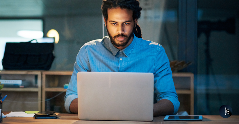 Mariner - Cybersecurity - Young designer working late on a laptop in an office